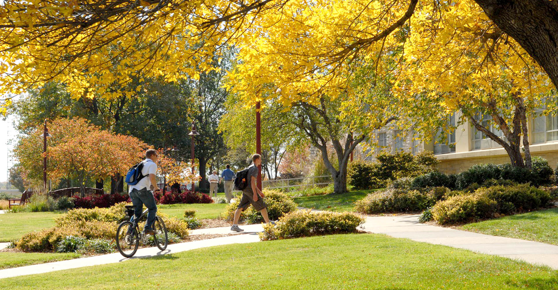 campus in fall with students walking and riding bikes