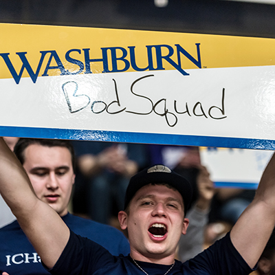 A student holds a Bod Squad sign during a Washburn basketball game