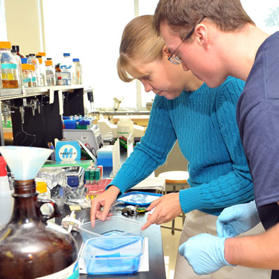 Biology instructor and student working with chemicals