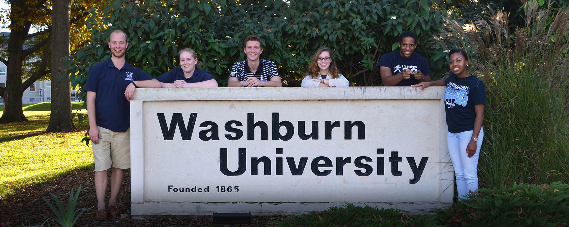 FYE students pose for a photo by the Washburn University sign.