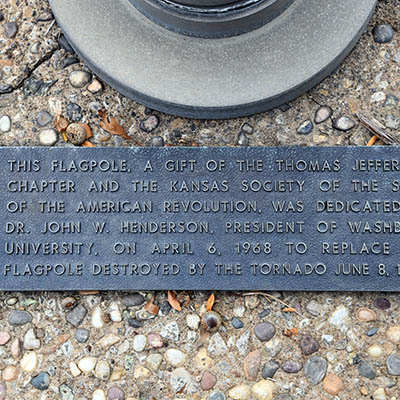 A plaque marks the replacement flag poles damaged in the 1966 tornado.