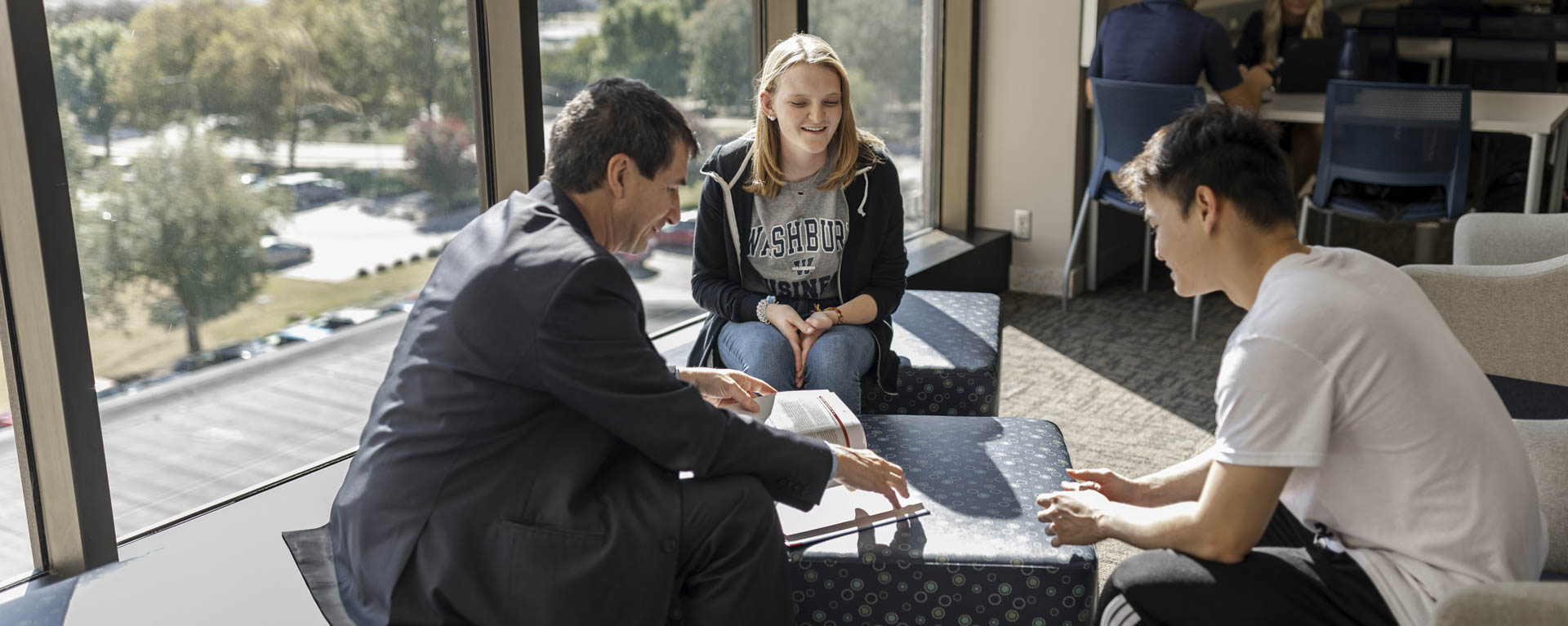 A business professor works with a small group of students.