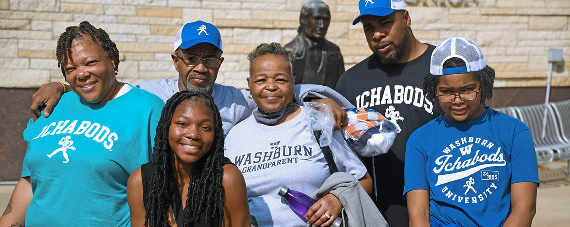 A family wearing Washburn clothing poses for a photo on Family Day.