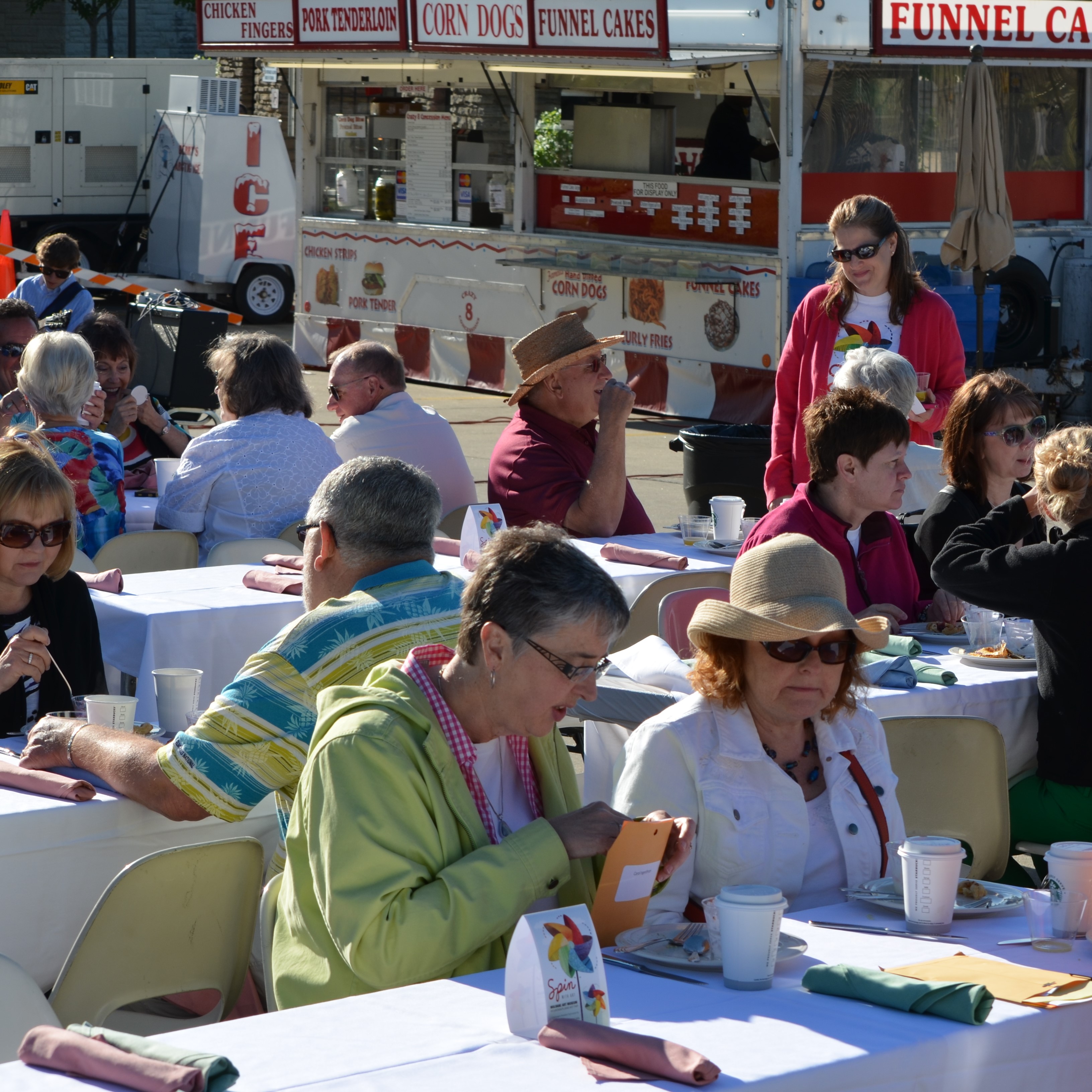 People eating at Art Fair next to food trucks
