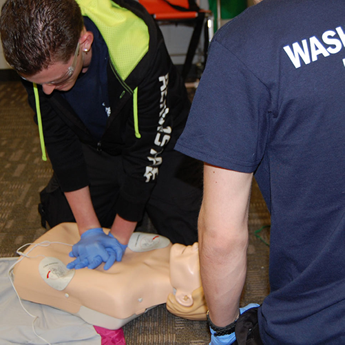 man giving CPR to human dummy