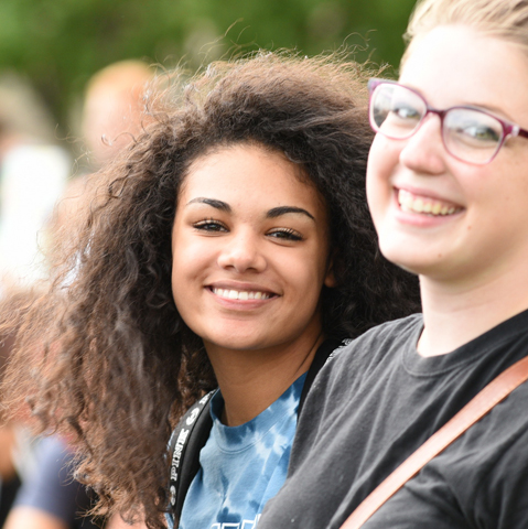 Two female students on campus smiling