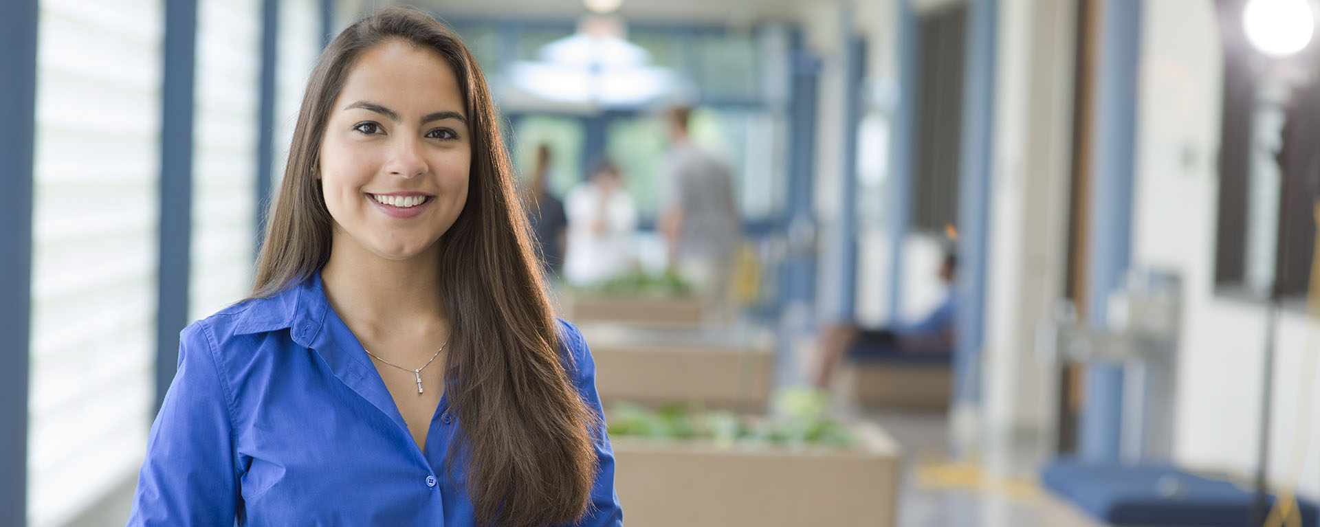 Female student smiling in office space hallway