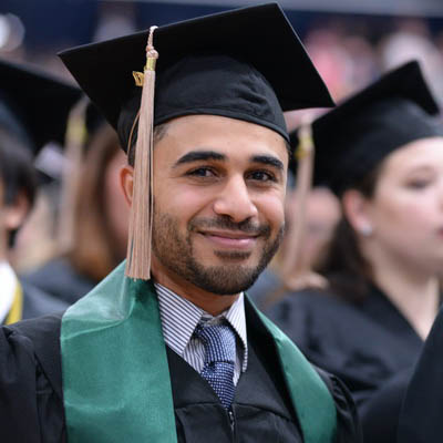 Graduating female student smiling at commencement.