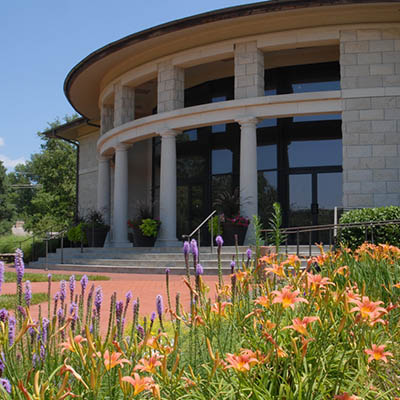 Flowers bloom in front of a building on campus.