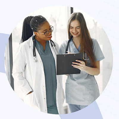 two medical workers looking at a clip board smiling