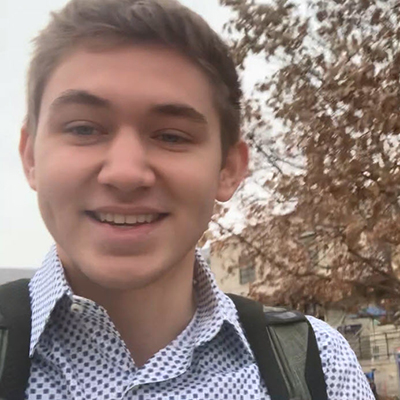 Quinn smiling while walking through campus