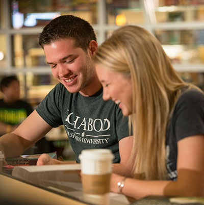 Two Washburn students work on an assignment outside of the Corner Store in the Memorial Union