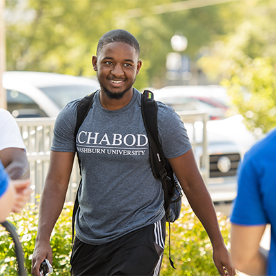 A student smiles while walking to class