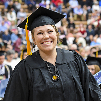 A graduate smiles widely during the ceremony