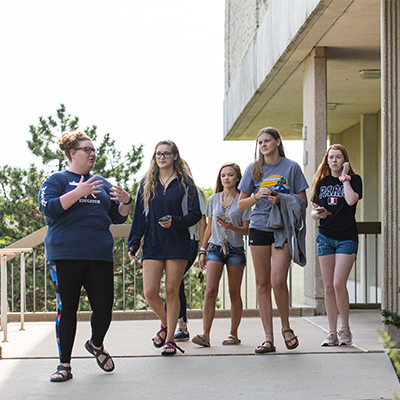 A student shows a group of students around the library