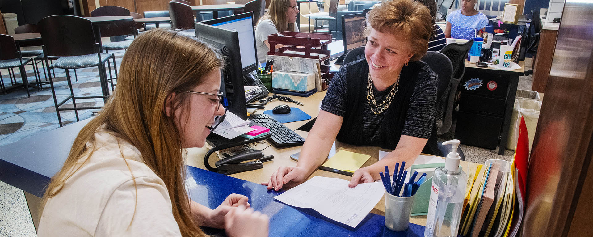 A Student One Stop staff member assists a Washburn student in the Welcome Center.