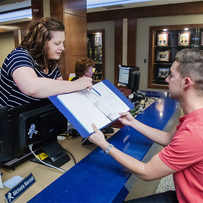 A student signs for a transcript