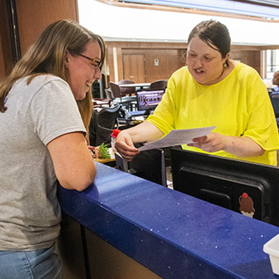 A student is assisted by a Student One Stop worker