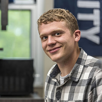 A Washburn student smiles in his room at Lincoln Hall, a state-of-the-art residence hall that opened in 2016.