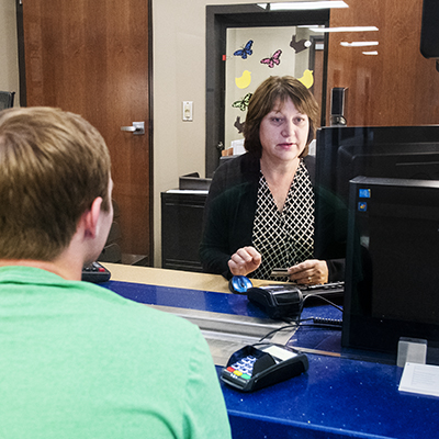 A student is helped at the business office window.