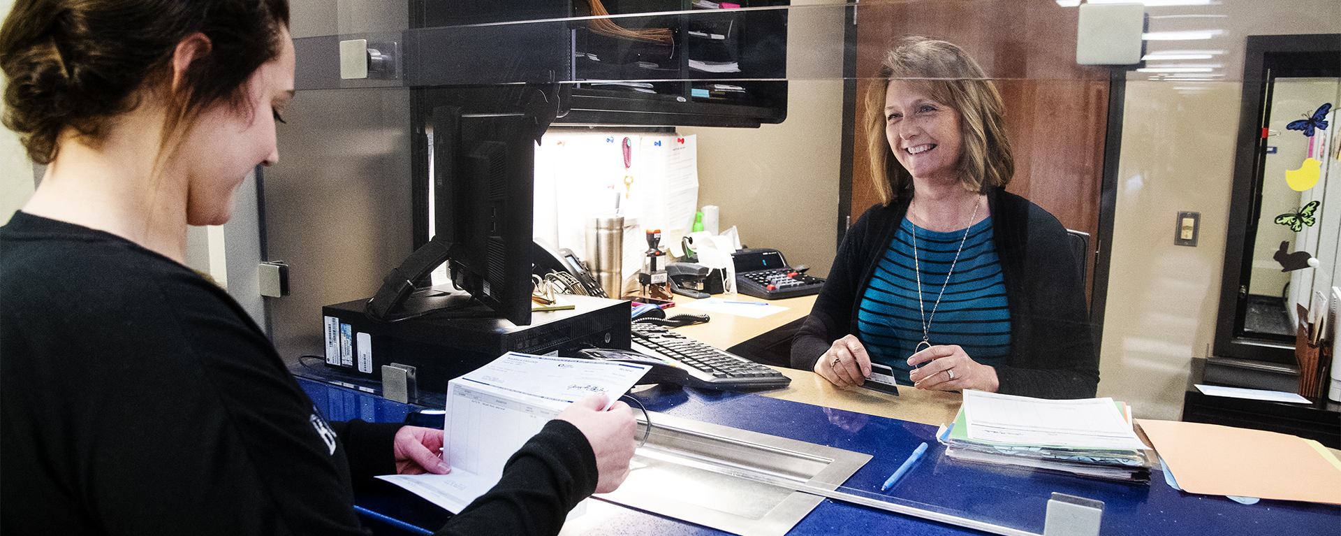 A Washburn student holds a refund check at the Business Office window in Morgan Hall.