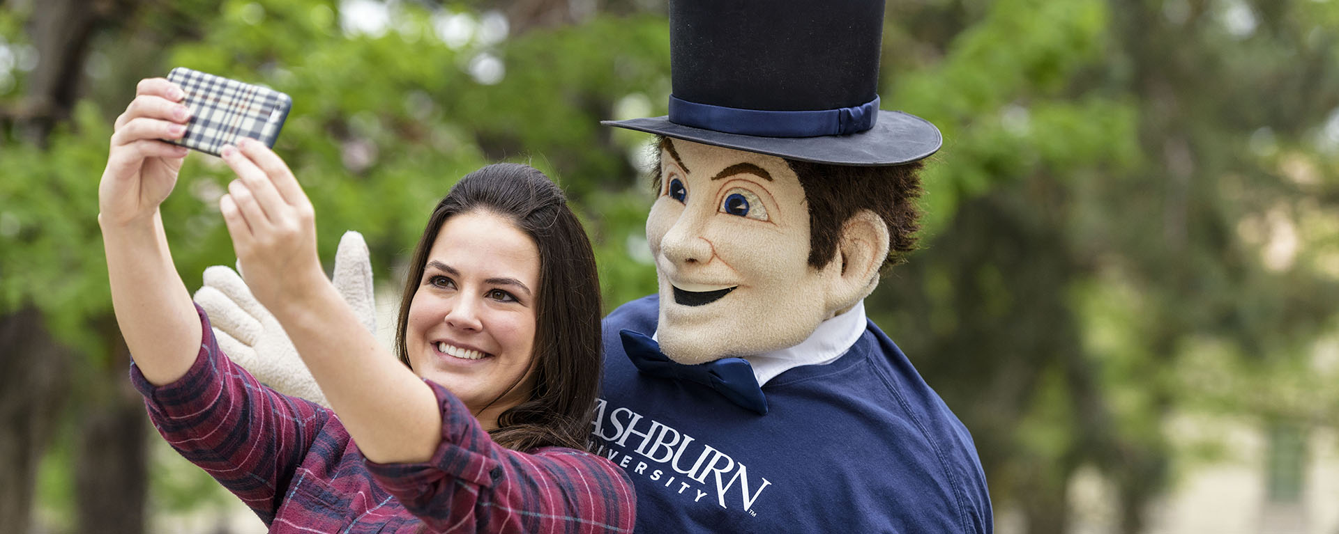 A Washburn student takes a selfie with Mr. Ichabod.