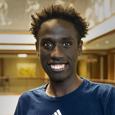 Washburn Summer Orientation Counselor David smiles while wearing a Washburn shirt