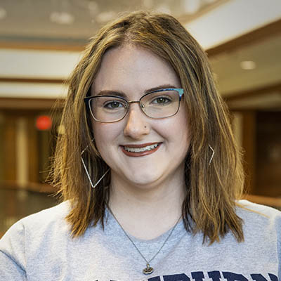 Washburn Summer Orientation Counselor Olivia smiles while wearing a Washburn shirt