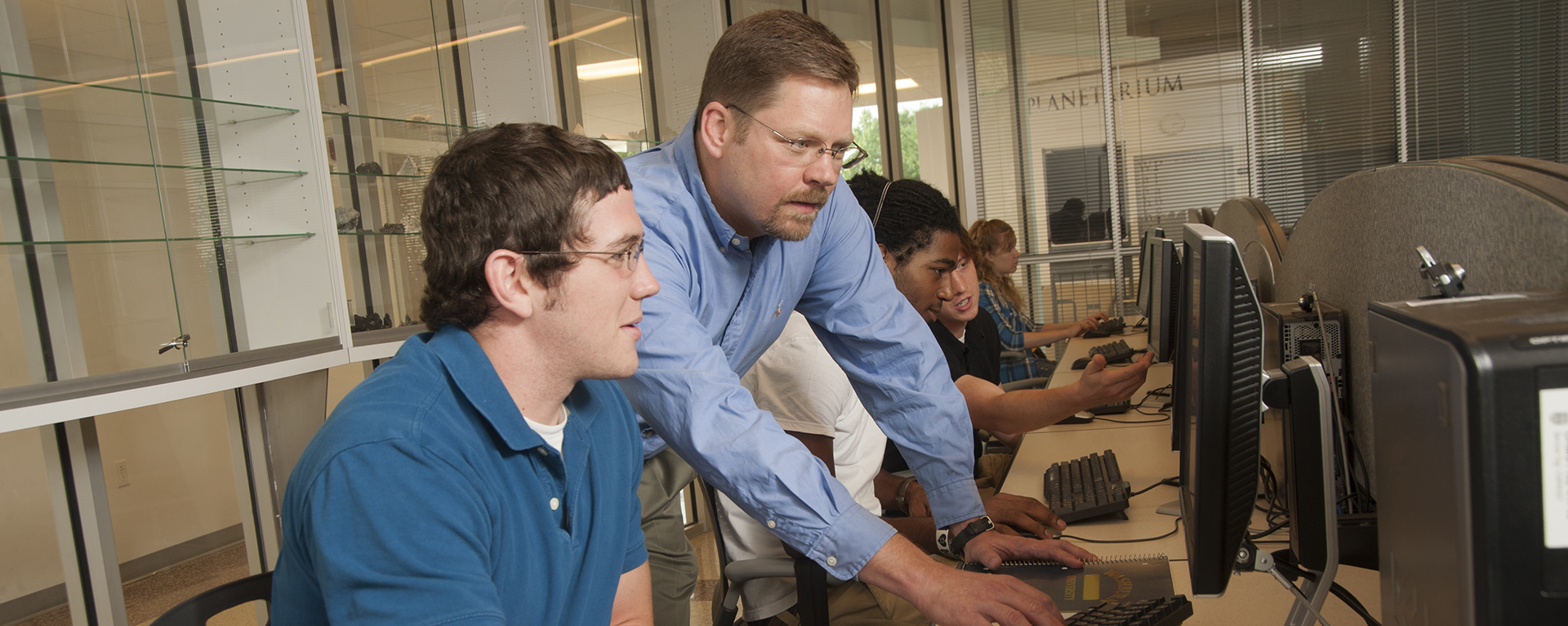 A Washburn biology professor works with a student during class.