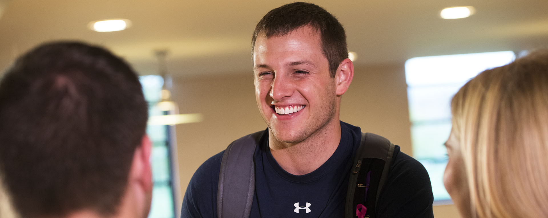 A student smiles while talking to friends in the Washburn student union.