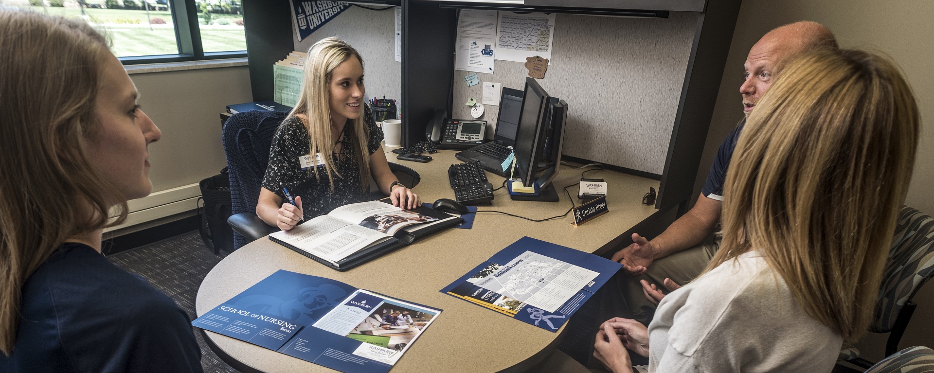 A Washburn admissions counselor meets with a prospective student and her parents in the Welcome Center.