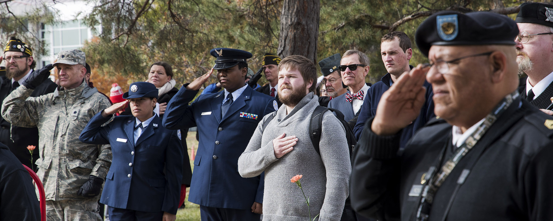 Veterans and students salute and honor the flag on Veterans Day in 2017