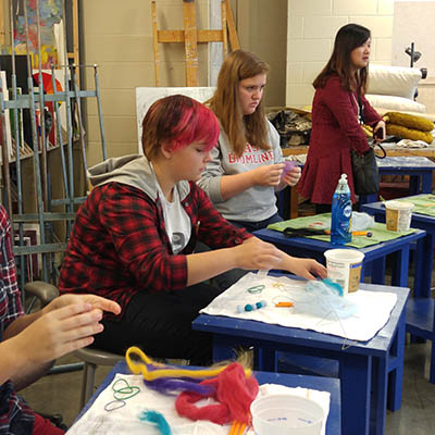 Art students work on a computer.