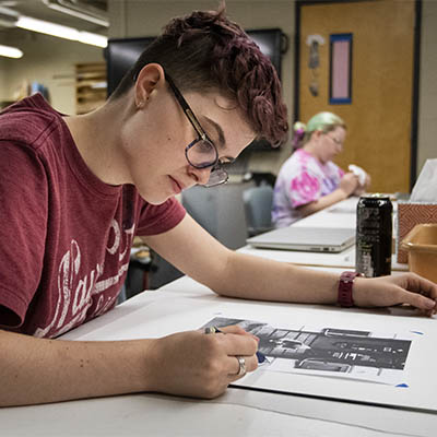 student at desk creating art