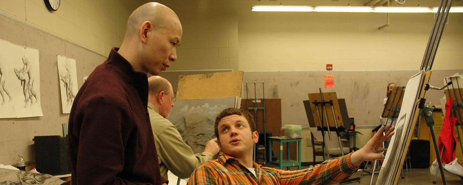 Professor and student discussing student's drawing