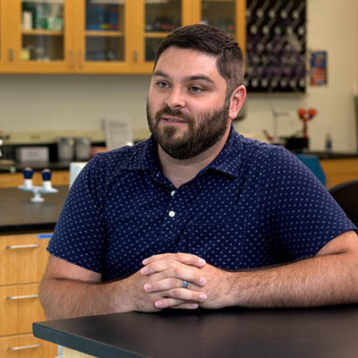Bill smiles while sitting in a biology lab