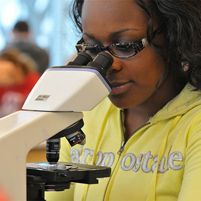 A student looks through a microscope.