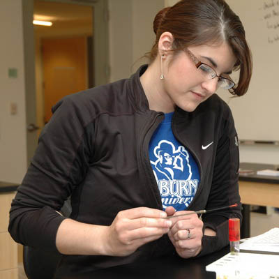 A student carefully works on an experiment