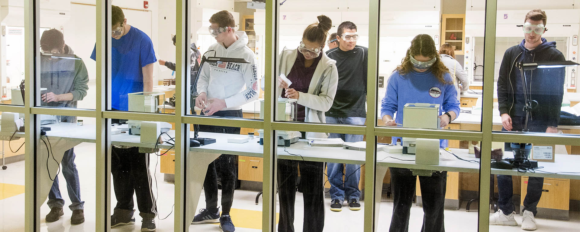 Students weigh components for an experiment in a lab