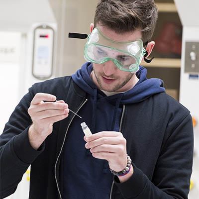 A student focuses on his experiment in a lab on campus