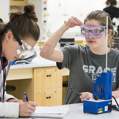 A student holds up a beaker while working on a lab