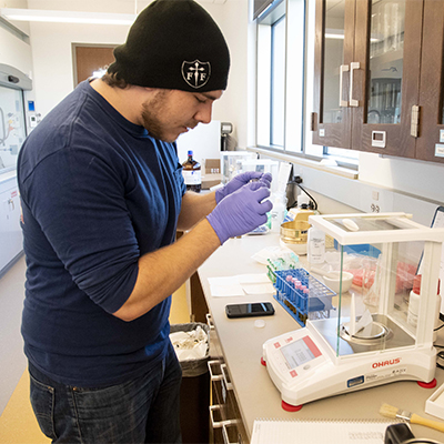 A chemistry professor and student talk in a lab