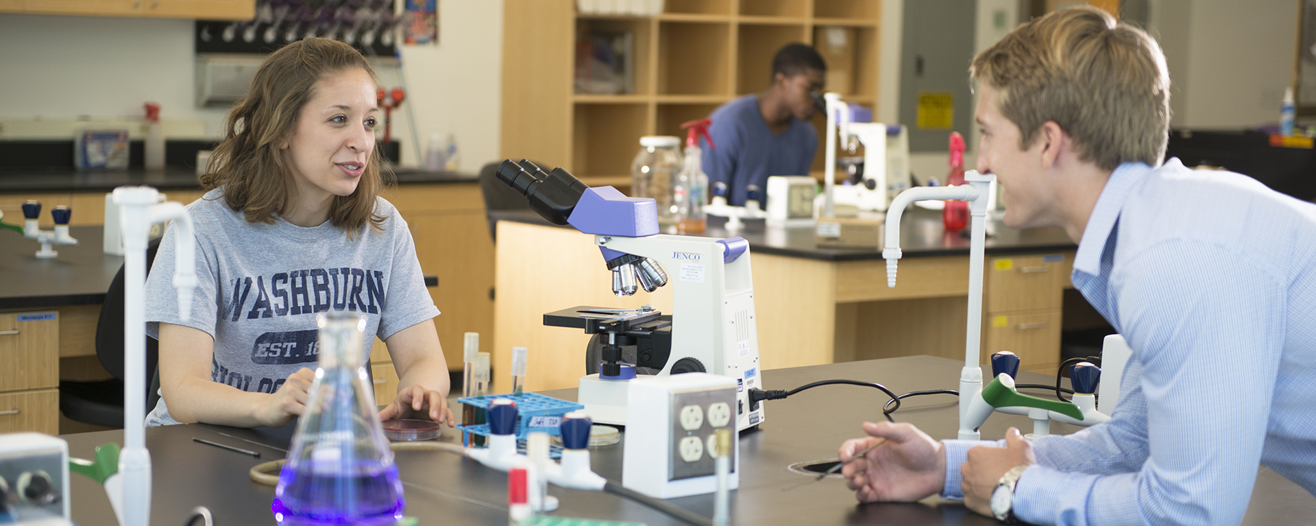 Students discussing while in a chemistry lab