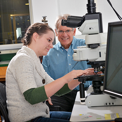 A professor and chemistry student work in a lab