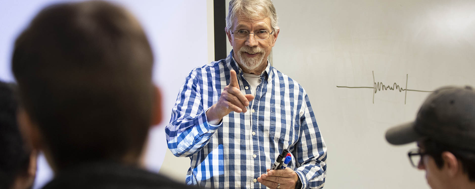 A professor smiles while teaching a programming class