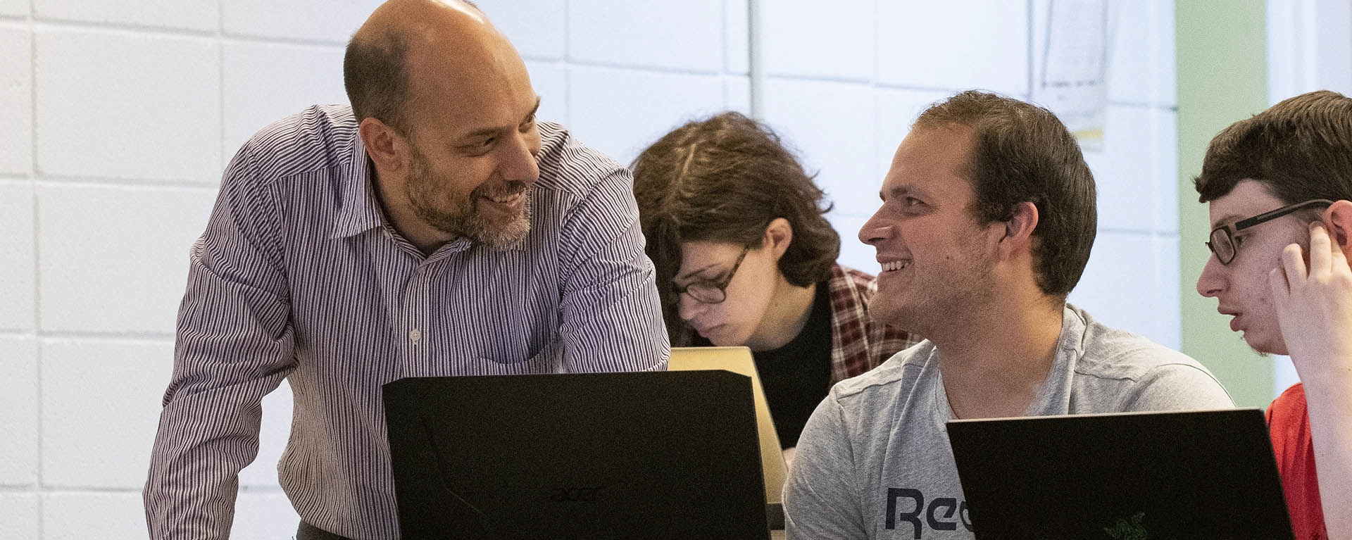 A computer information science professor helps a student with an exercise during class.