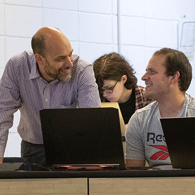 A professor helps a student while in class