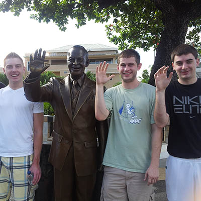 Students pose for a photo with a statue in Puerto Rico.