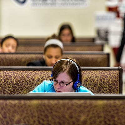 A student works on a laptop in the library