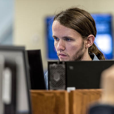 A student concentrates while working on a pc